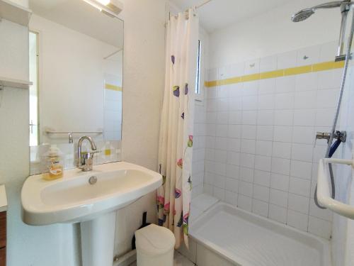 une salle de bain blanche avec un lavabo et une baignoire dans l'établissement Villa T3 Mezzanine - Parking Privé - À 6 min de la plage - 6 pers. - Narbonne-Plage - FR-1-795-62, à Narbonne