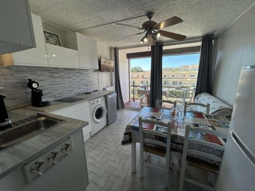une cuisine avec une table et une salle à manger dans l'établissement Appartement 2 pièces au Grau-du-Roi avec piscine et parking - FR-1-250-304, au Grau-du-Roi