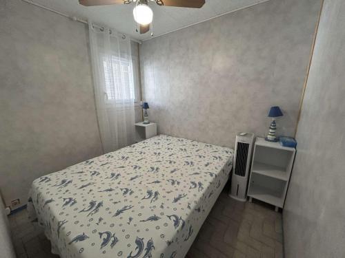 une petite chambre avec un lit et une fenêtre dans l'établissement Appartement 2 pièces au Grau-du-Roi avec piscine et parking - FR-1-250-304, au Grau-du-Roi