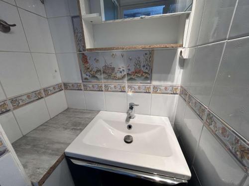 une salle de bain avec un lavabo blanc et un miroir dans l'établissement Appartement 2 pièces au Grau-du-Roi avec piscine et parking - FR-1-250-304, au Grau-du-Roi