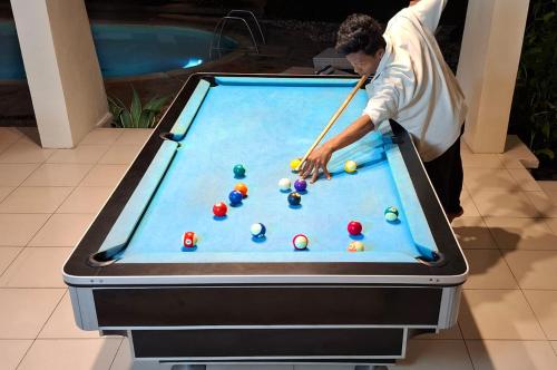 a man playing pool on a pool table at Deva Bali Villa in Kerobokan