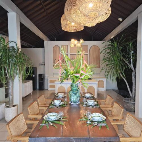a dining room with a table and chairs and a chandelier at Deva Bali Villa in Kerobokan