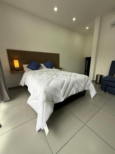 a bedroom with a large white bed with blue pillows at Hotel HS Confort in Orizaba