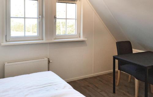 a bedroom with a bed and a desk and two windows at Buitengoed Het Lageveld - 84 in Hoge-Hexel