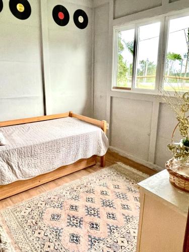 a bedroom with a bed and a window and a rug at Chácara Passaúna in Curitiba