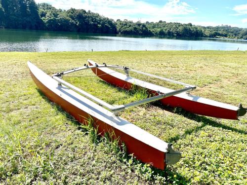 two boats sitting on the grass next to a lake at Chácara Passaúna in Curitiba