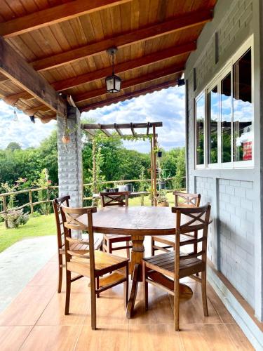 a wooden table and chairs on a patio at Chácara Passaúna in Curitiba