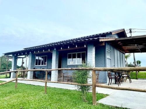 a blue house with a picnic table in front of it at Chácara Passaúna in Curitiba