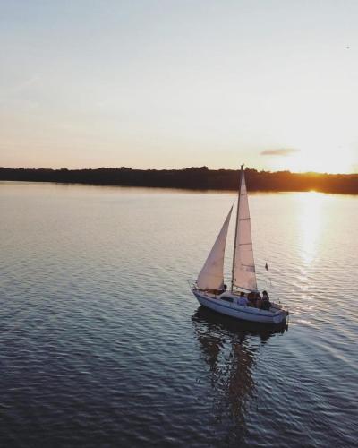 a small sail boat in the water at sunset at Chácara Passaúna in Curitiba