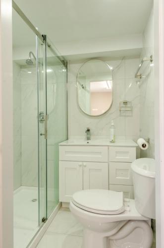 a bathroom with a toilet and a glass shower at Convenient Urban Retreat in Vancouver