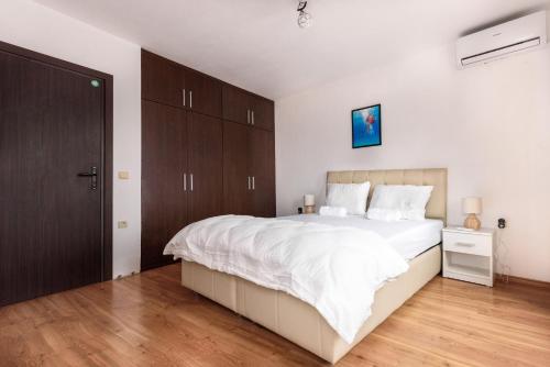 a bedroom with a large white bed and wooden cabinets at La Vista 1 in Veliko Tŭrnovo