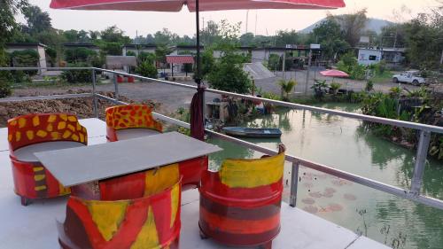 a table and chairs with an umbrella on a boat at เช็คอินรีสอร์ทชัยนาท Check-in resort in Ban Khao Khayai (1)