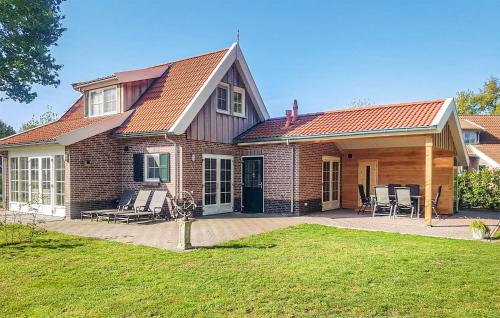 a brick house with a patio and chairs at Buitengoed Het Lageveld in Hoge-Hexel