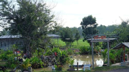 a view of a garden with a bridge and a pond at เช็คอินรีสอร์ทชัยนาท Check-in resort in Ban Khao Khayai (1)