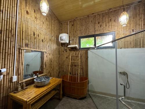 a bathroom with a wooden tub and a sink at Om Tara Retreat in Yen Bai