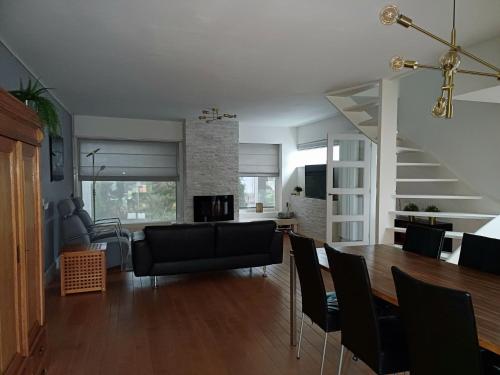 a dining room and living room with a table and chairs at Gehele woning in Nuenen in Nuenen