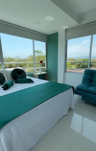 a bedroom with a large bed and large windows at Yopo Resort in Pedregal