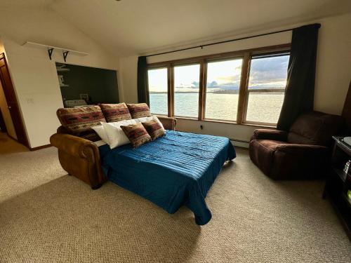 a bedroom with a bed and a couch and a window at Downtown Wasilla Lakefront Home in Wasilla