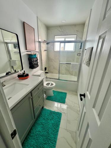 a bathroom with a shower and a toilet and a sink at Miramar Retreat Arcade Game Room King Bed 25 Min to Hollywood Beach in Miramar