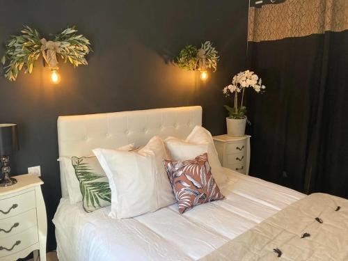 - une chambre avec un lit blanc et des oreillers dans l'établissement Villa les Romarins, à Saint-Didier