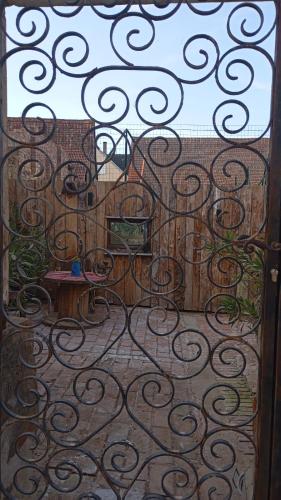 an iron gate with a table and chairs on a patio at Au coeur d'autrefois in Waldolwisheim
