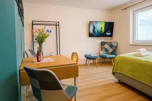 a room with a bed and a table with flowers on it at Savor City Appartement Bautzen für 2 Personen direkt im Zentrum in Bautzen