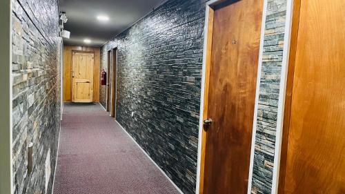 a hallway with a brick wall and a wooden door at Hostal Santa Fe in Castro