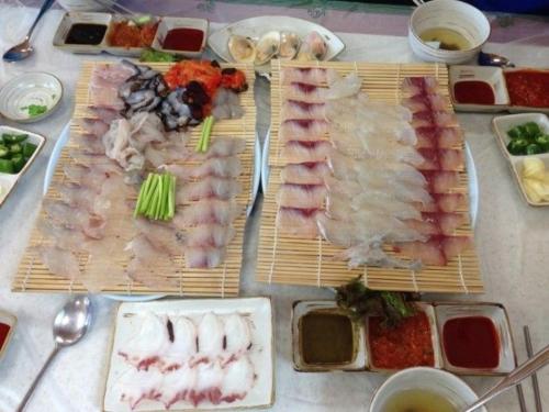 a table topped with different types of meats and vegetables at Stay D in Goseong