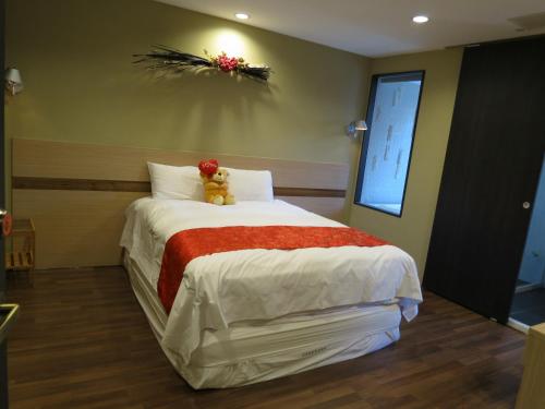 a bedroom with a bed with a teddy bear on it at 茶源旅店-潭暉魚池館 in Yuchi