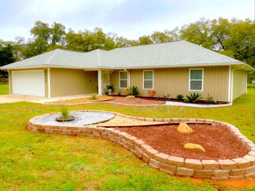 a house with a garden in front of it at Pensacola Coastal Retreat Near UWF Family-friendly in Olive