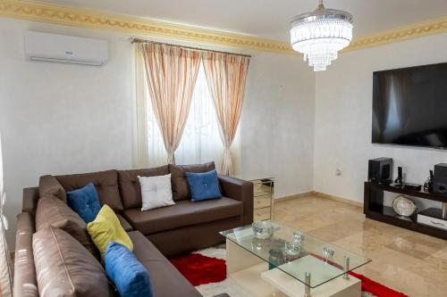 a living room with a couch and a tv at Villa La Dueña - Vista Hermosa Luxury Retreat, 5BR Villa with Pool, Swim-Up Bar, Jacuzzi, Chef's Kitchen, Fast Wi-Fi, Full AC, EV Charger and Solar Power, Ideal for Families & Groups in Cancino