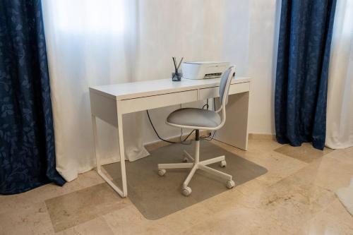 a white desk with a chair and a printer on it at Villa La Dueña - Vista Hermosa Luxury Retreat, 5BR Villa with Pool, Swim-Up Bar, Jacuzzi, Chef's Kitchen, Fast Wi-Fi, Full AC, EV Charger and Solar Power, Ideal for Families & Groups in Cancino