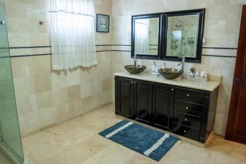 a bathroom with two sinks and a shower at Villa La Dueña - Vista Hermosa Luxury Retreat, 5BR Villa with Pool, Swim-Up Bar, Jacuzzi, Chef's Kitchen, Fast Wi-Fi, Full AC, EV Charger and Solar Power, Ideal for Families & Groups in Cancino