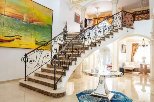 a staircase in a home with a painting on the wall at Villa La Dueña - Vista Hermosa Luxury Retreat, 5BR Villa with Pool, Swim-Up Bar, Jacuzzi, Chef's Kitchen, Fast Wi-Fi, Full AC, EV Charger and Solar Power, Ideal for Families & Groups in Cancino