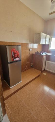 a small kitchen with a refrigerator in a room at Al Rawas Son Apartment in Salalah