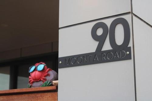 a sign on a building with a moontario road sign at The Coastal Crab, Moonta Bay in Port Moonta