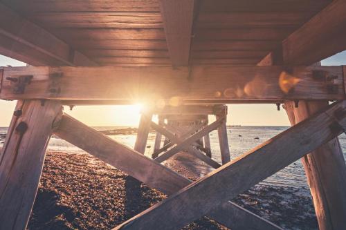 a wooden table on the beach with the sun setting at The Coastal Crab, Moonta Bay in Port Moonta