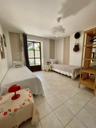 - une grande chambre avec 2 lits et une fenêtre dans l'établissement Maison de Charme Provençale, à Saint-Victor-la-Coste