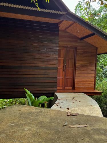 a wooden building with a door on a patio at Hillhouse - Koh Yao Noi in Ko Yao Noi