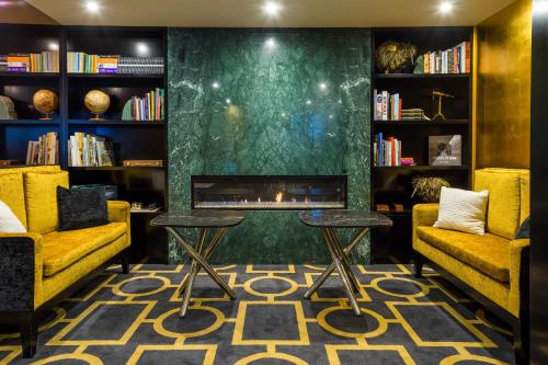 a living room with two chairs and a fireplace at Bolton Hotel in Wellington