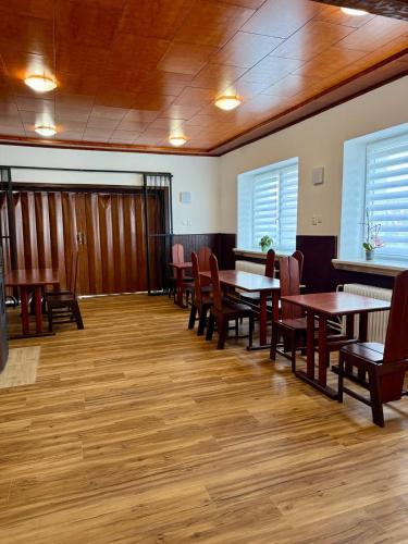 a dining room with tables and chairs and wooden floors at Penzion Horní Bradlo in Horní Bradlo
