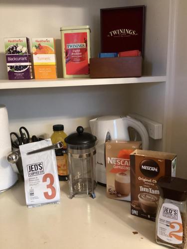 a kitchen counter with food items on a shelf at The Old School House bed and breakfast in Greytown