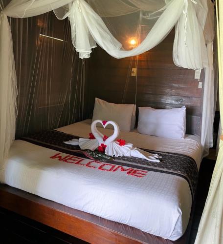 a bedroom with a bed with a swan on it at Hillhouse - Koh Yao Noi in Ko Yao Noi