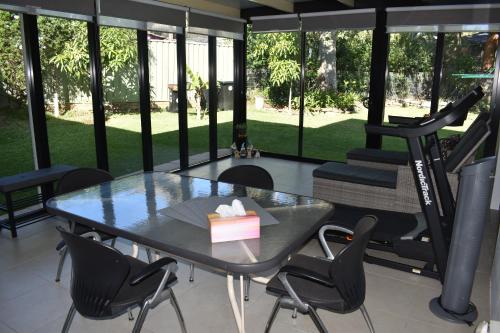 a room with a table and a gym with a treadmill at Garden Hideaway-Entirely Private in Beecroft
