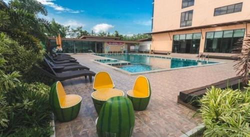 een zwembad met enkele stoelen en een gebouw bij phatra boutique hotel in Udon Thani