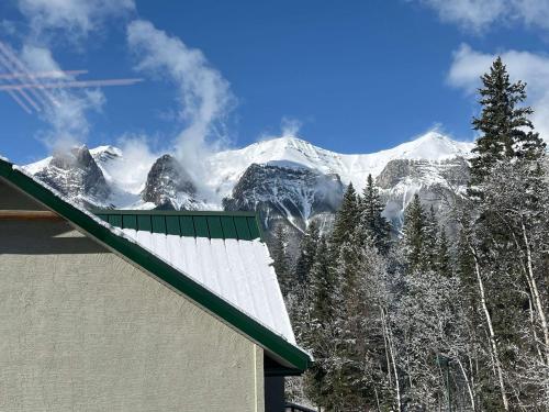 a view of a snow covered mountain from a house at Banff Woods lodge in Canmore