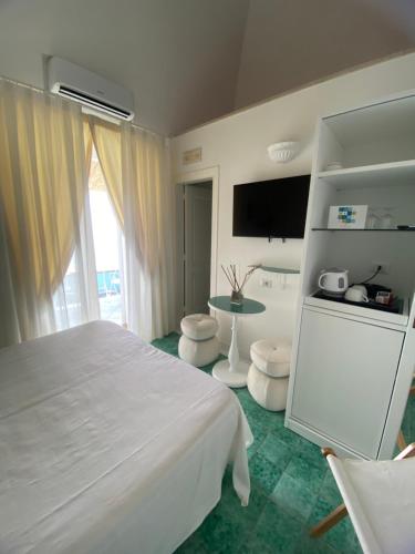 a bedroom with a white bed and a tv at Palazzo Talamo in Positano