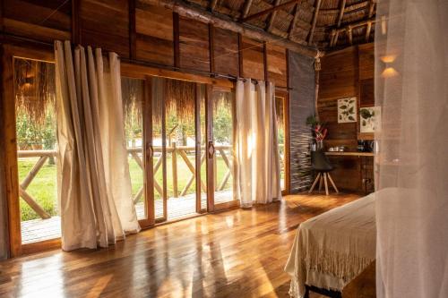 a bedroom with a bed and large sliding glass doors at Anahari Centro Wellness in Quimbaya