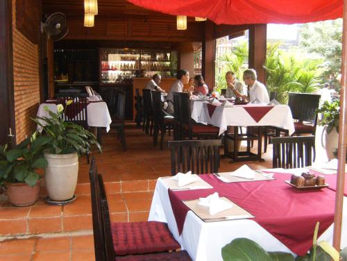 a group of people sitting at tables in a restaurant at Shining Angkor Boutique Hotel in Siem Reap