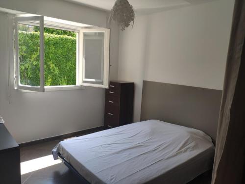 une chambre avec un lit et une fenêtre dans l'établissement 3 pièces 67m2 centre ville très lumineux et calme, à Nice